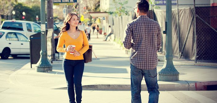 man and woman crossing paths on the street