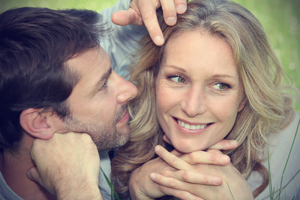 close up of a man moving the hair out of woman's face