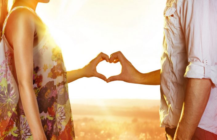 couple making a heart with their hands