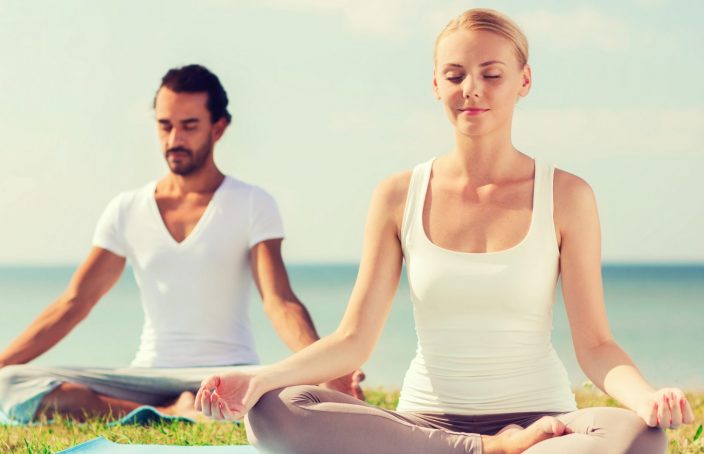 man and woman doing yoga outside