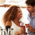 man charms a woman at a bar