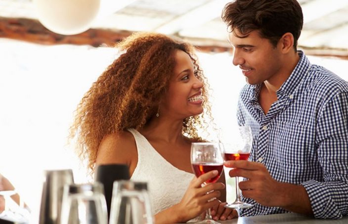 man charms a woman at a bar